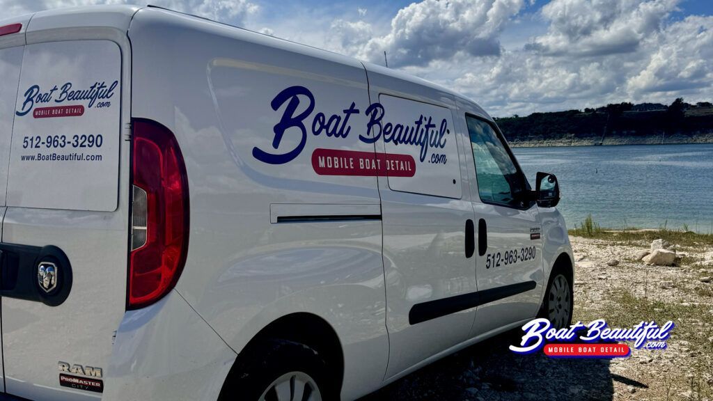 A white van is parked next to a body of water.