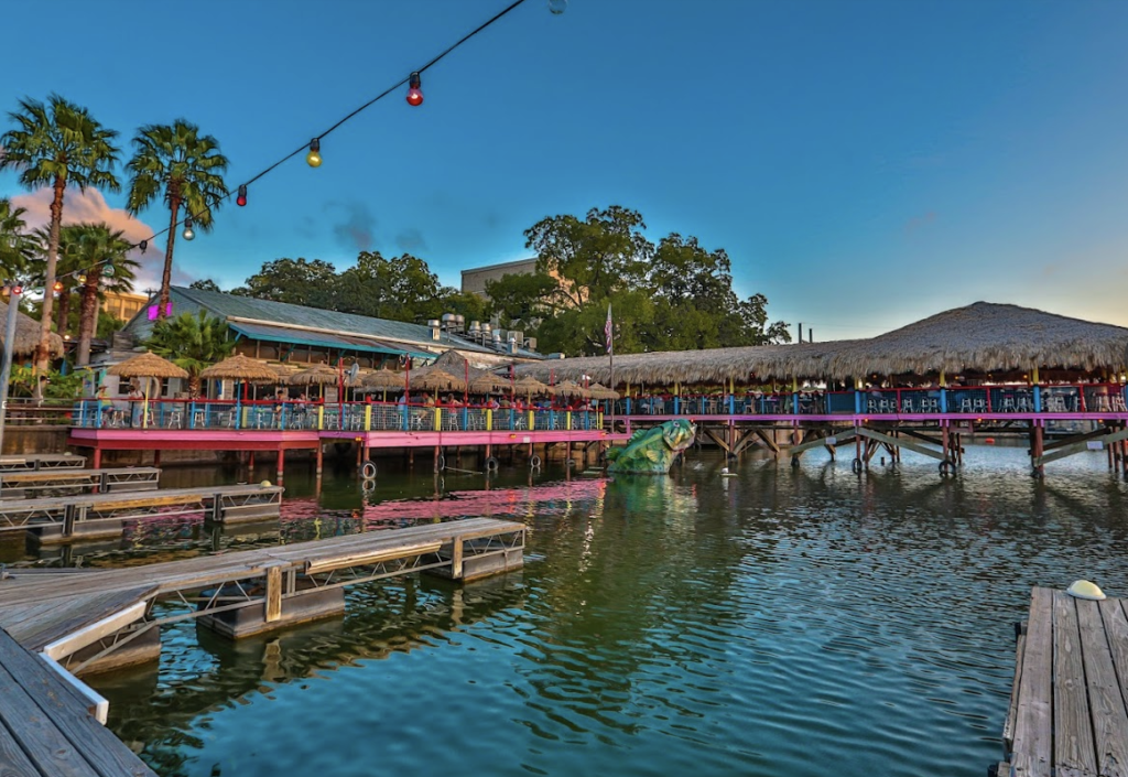 A dock overlooking a body of water with a building in the background.