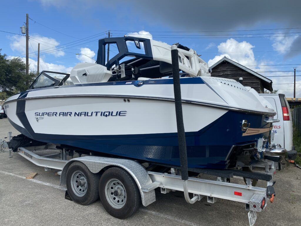 A blue and white boat is on a trailer.