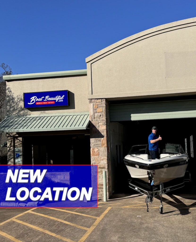 A man is standing next to a boat in front of a building that says new location