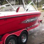 A red boat is sitting on top of a red trailer.