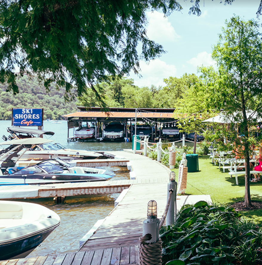 Boats are docked at a dock with a sign that says ski shores