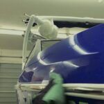 A person is standing in front of a surgical machine in an operating room.