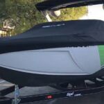 A boat is sitting on top of a trailer with a cover on it.