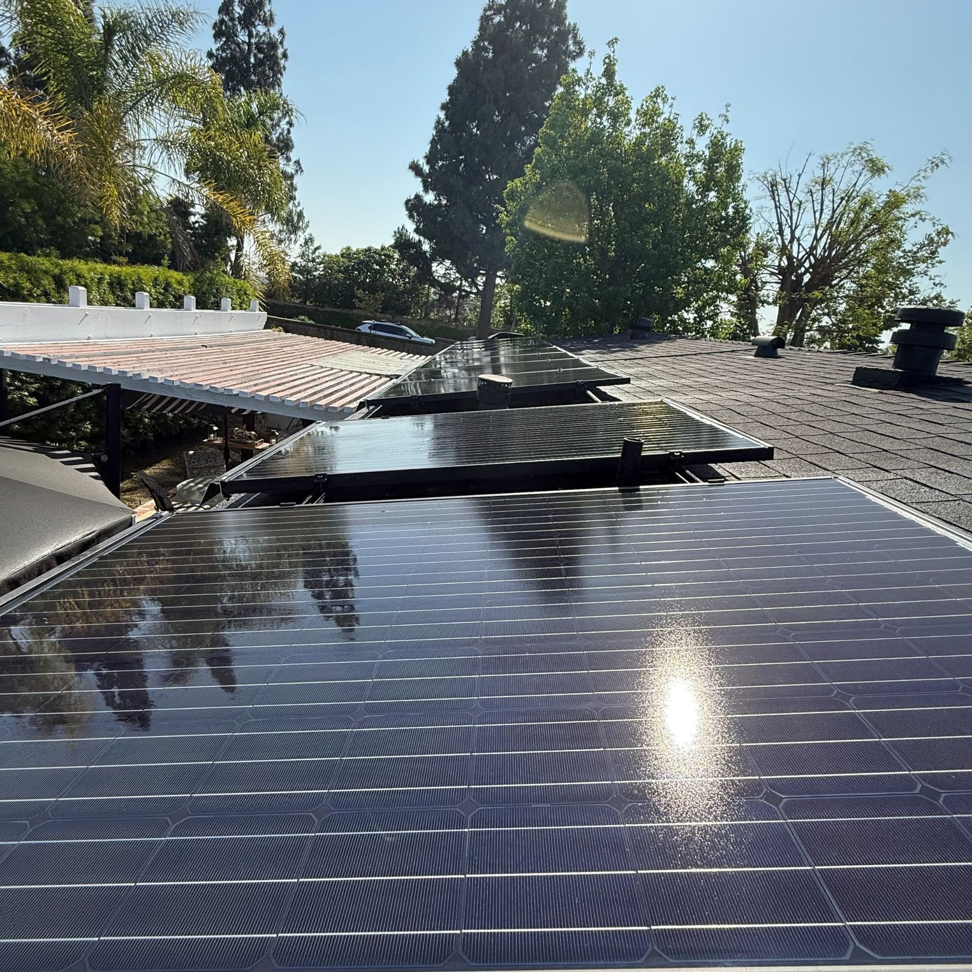 NFG Solar Panel Cleaning Company - A row of solar panels are sitting on top of a roof.