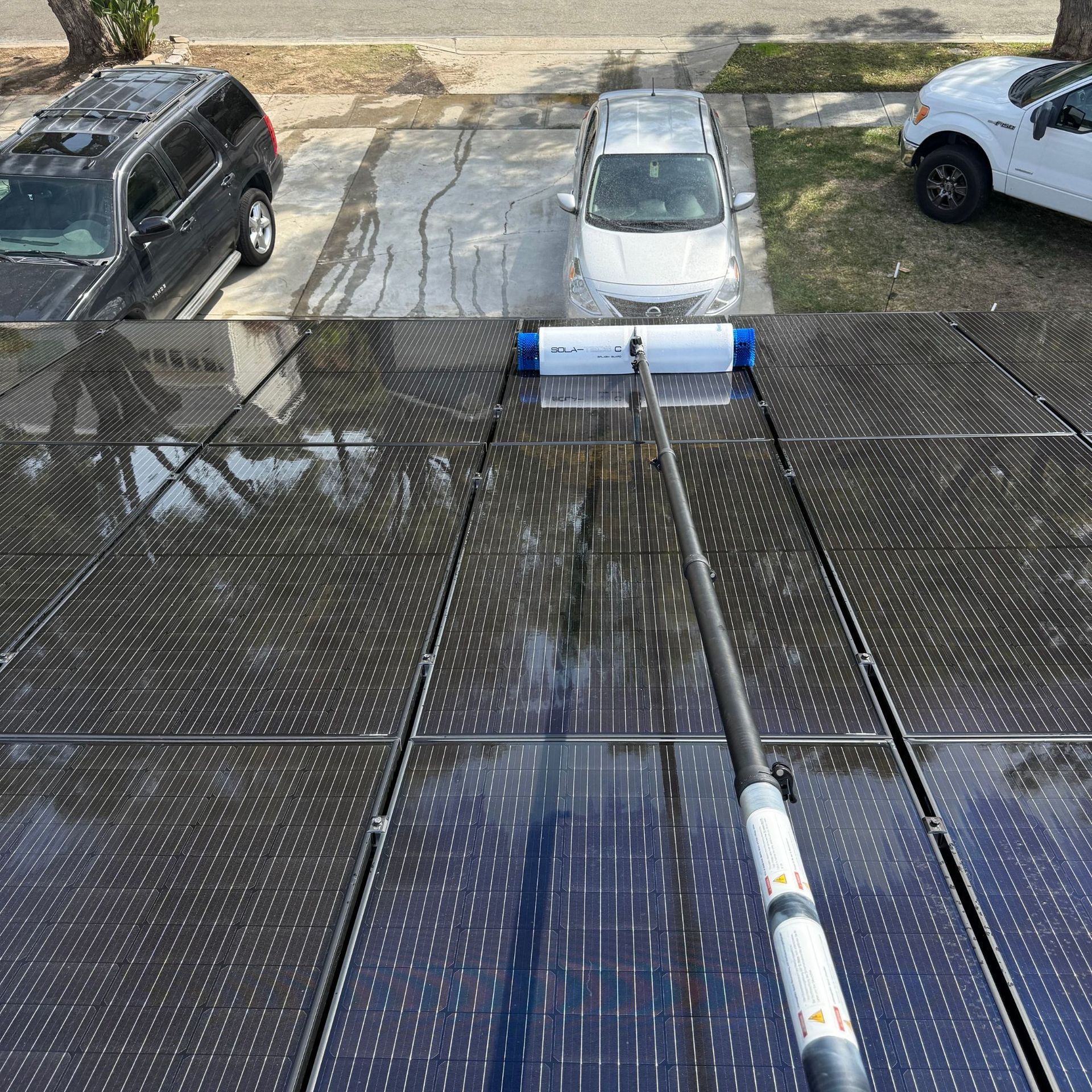 NFG Solar Panel Cleaning Company - A person is cleaning a solar panel with a brush.