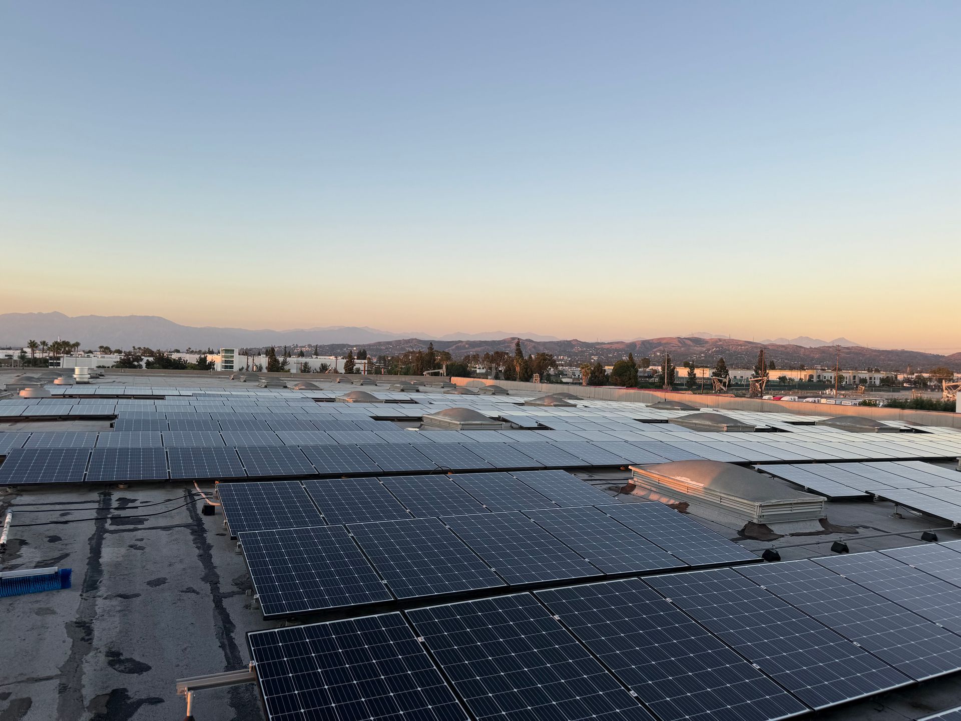 NFG Solar Panel Cleaning Company - A row of solar panels are sitting on top of a roof.