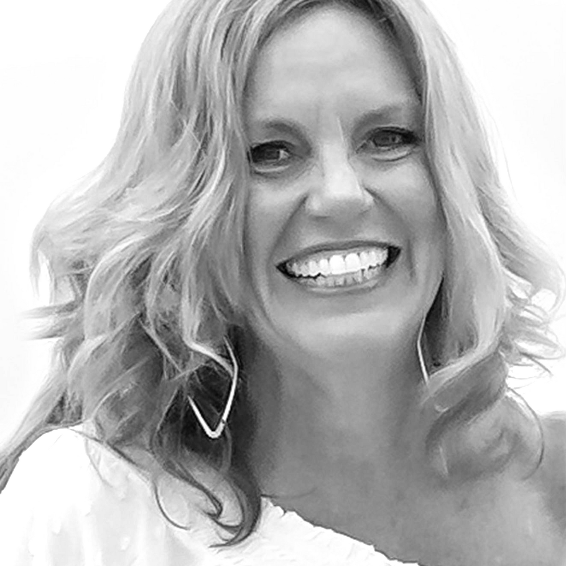 A smiling person with wavy hair and triangle-shaped earrings against a plain background.