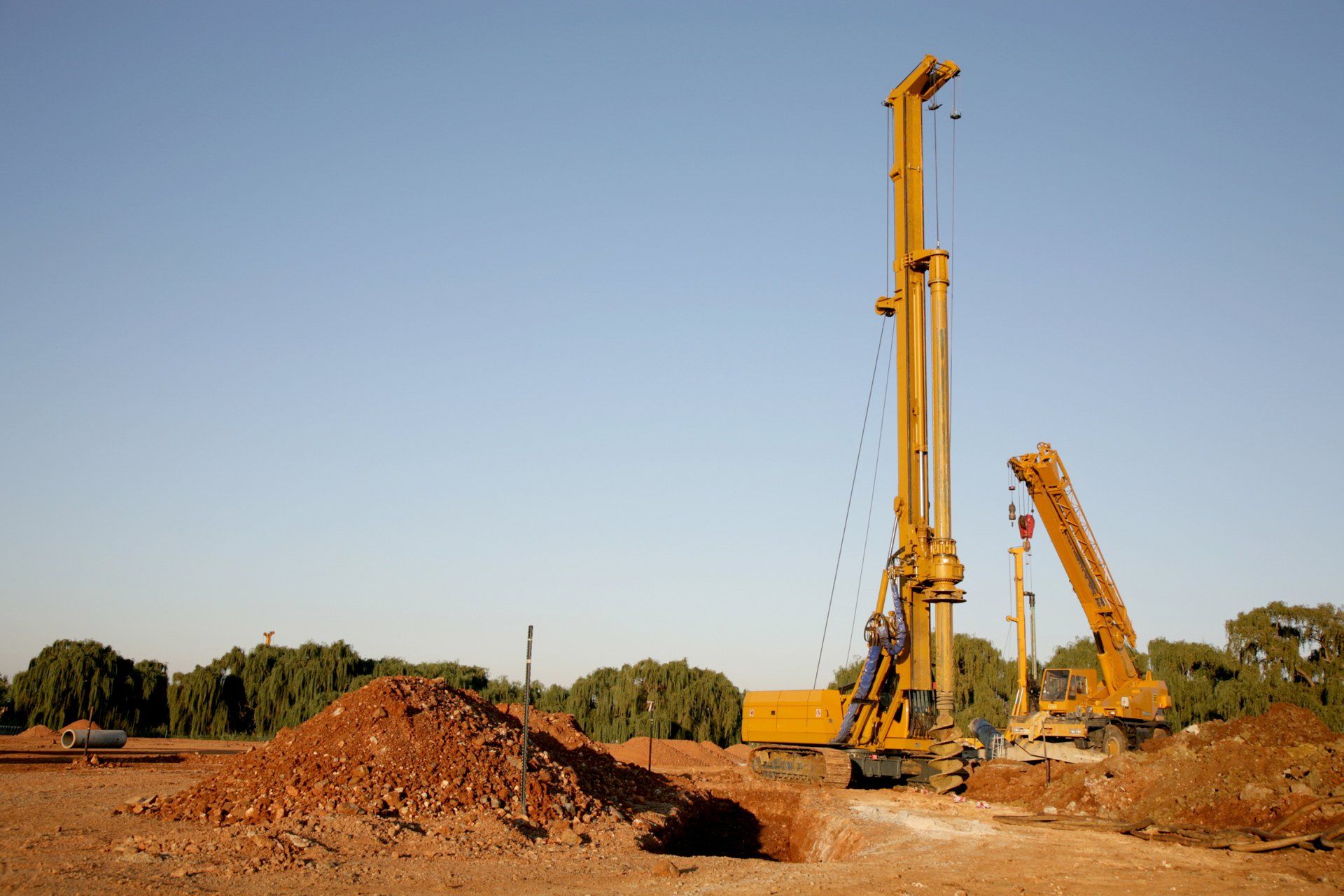 A Big Yellow Drill Digging Holes In The Ground - Tekcon in Alice Springs, NT