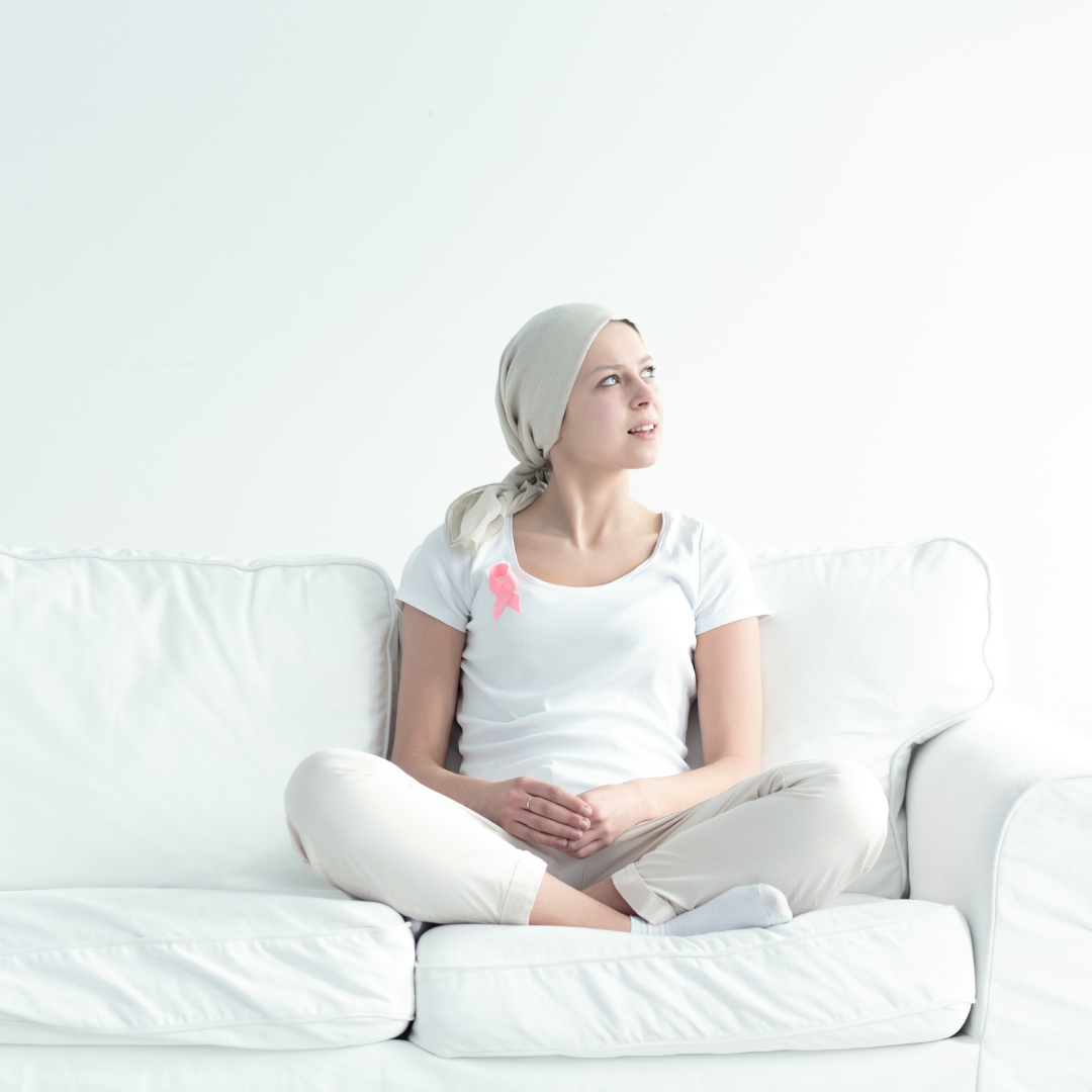 Una mujer está sentada en un sofá blanco con las piernas cruzadas.