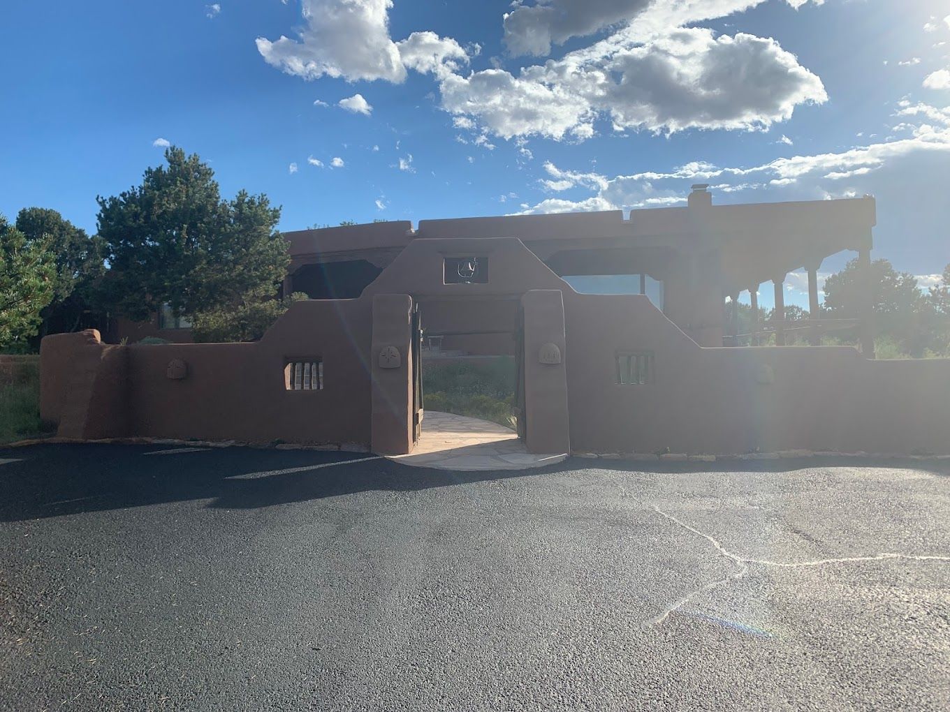 A large house with a fence around it and a driveway leading to it.