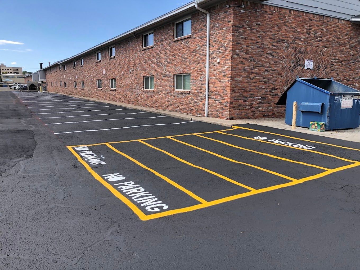 A brick building with a parking lot in front of it