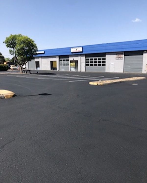 A parking lot in front of a building with a blue roof