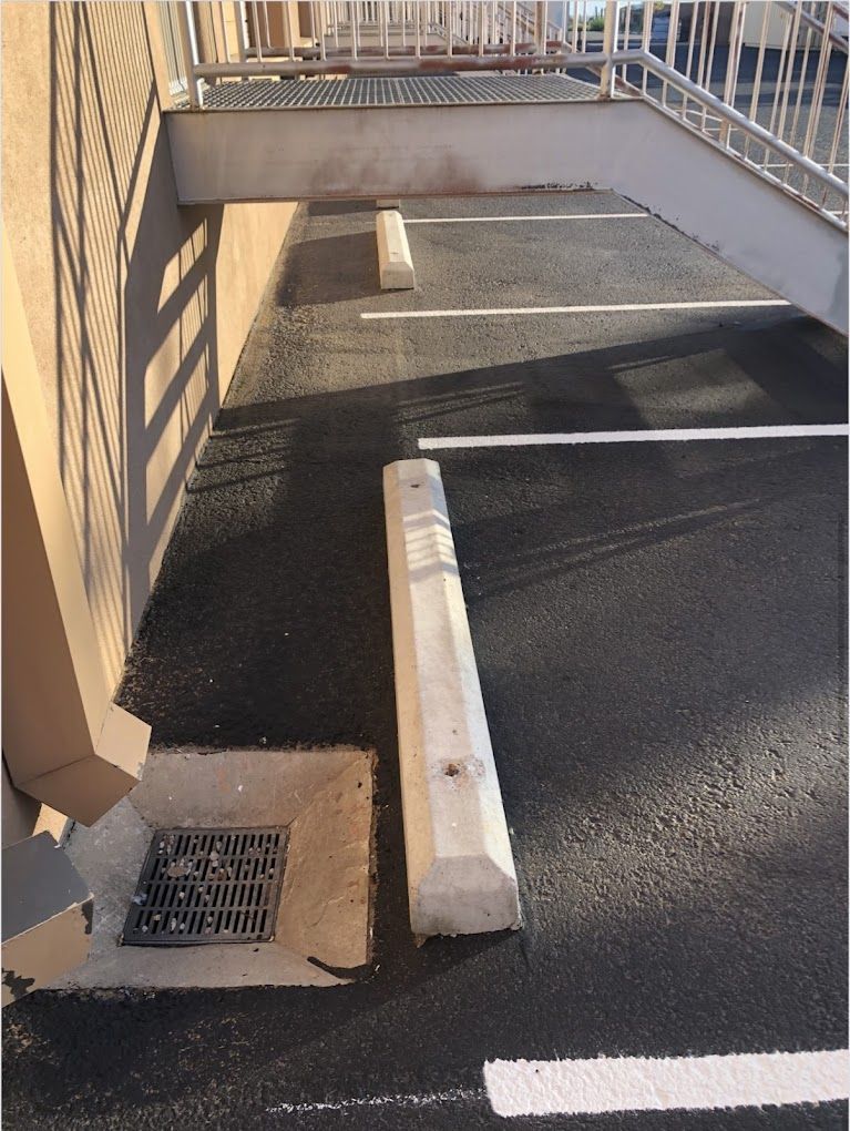 A parking lot with white lines and a white curb