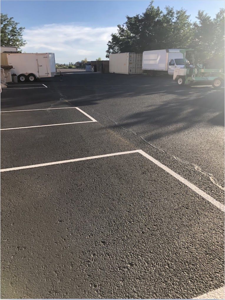A truck is parked in a parking lot next to a trailer