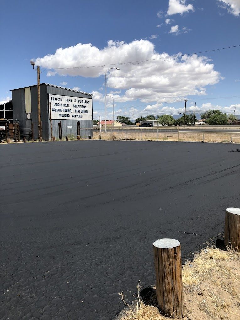 A large empty parking lot with a building in the background.