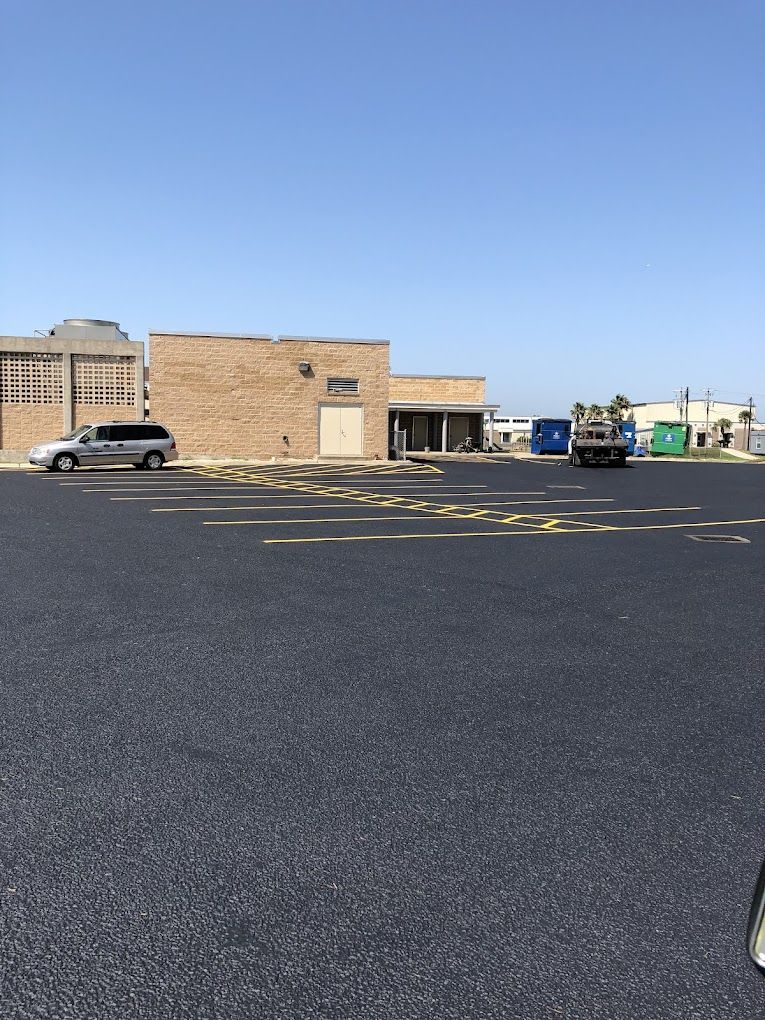 A parking lot with cars parked in front of a building.