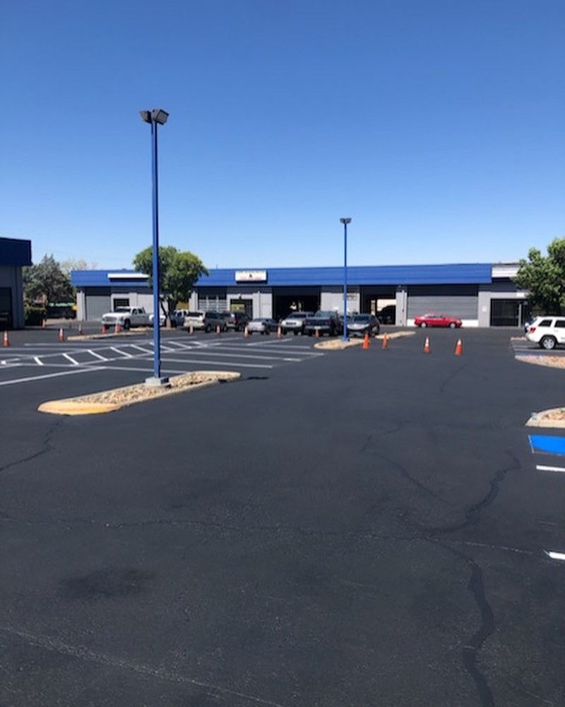 A parking lot with cars parked in front of a building