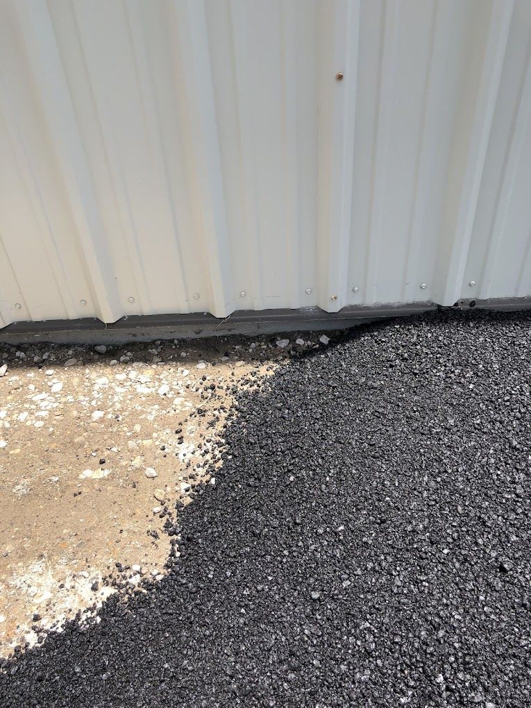 There is a lot of gravel on the ground in front of a building.