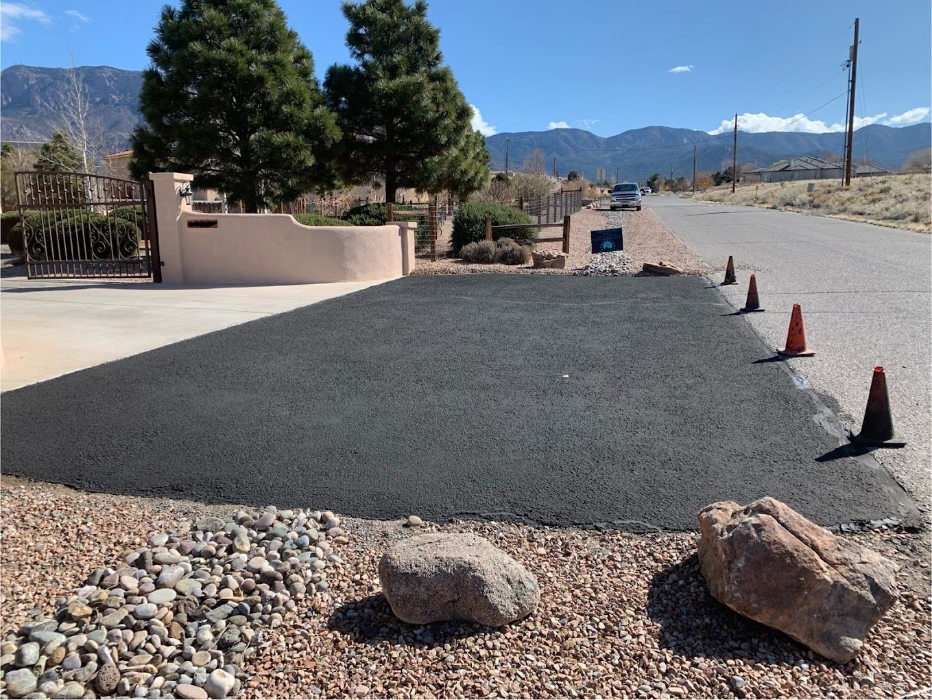 A row of traffic cones are sitting on the side of a road.