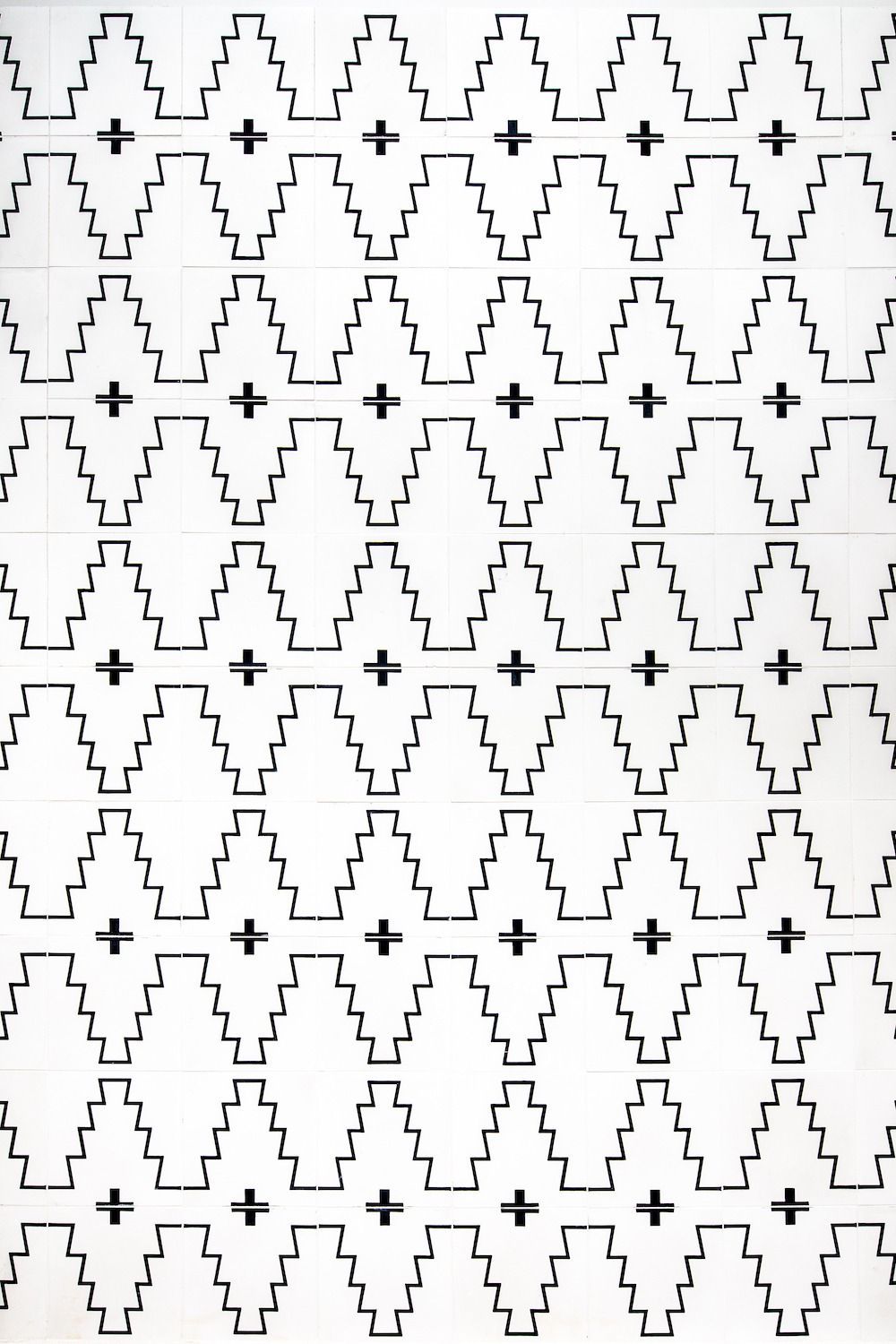 Black and white pattern of vertically repeating, stepped diamond shapes with small centered plus signs.
