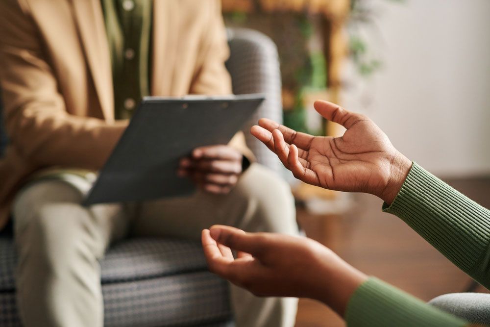A woman is reaching out her hand towards a man holding a clipboard.