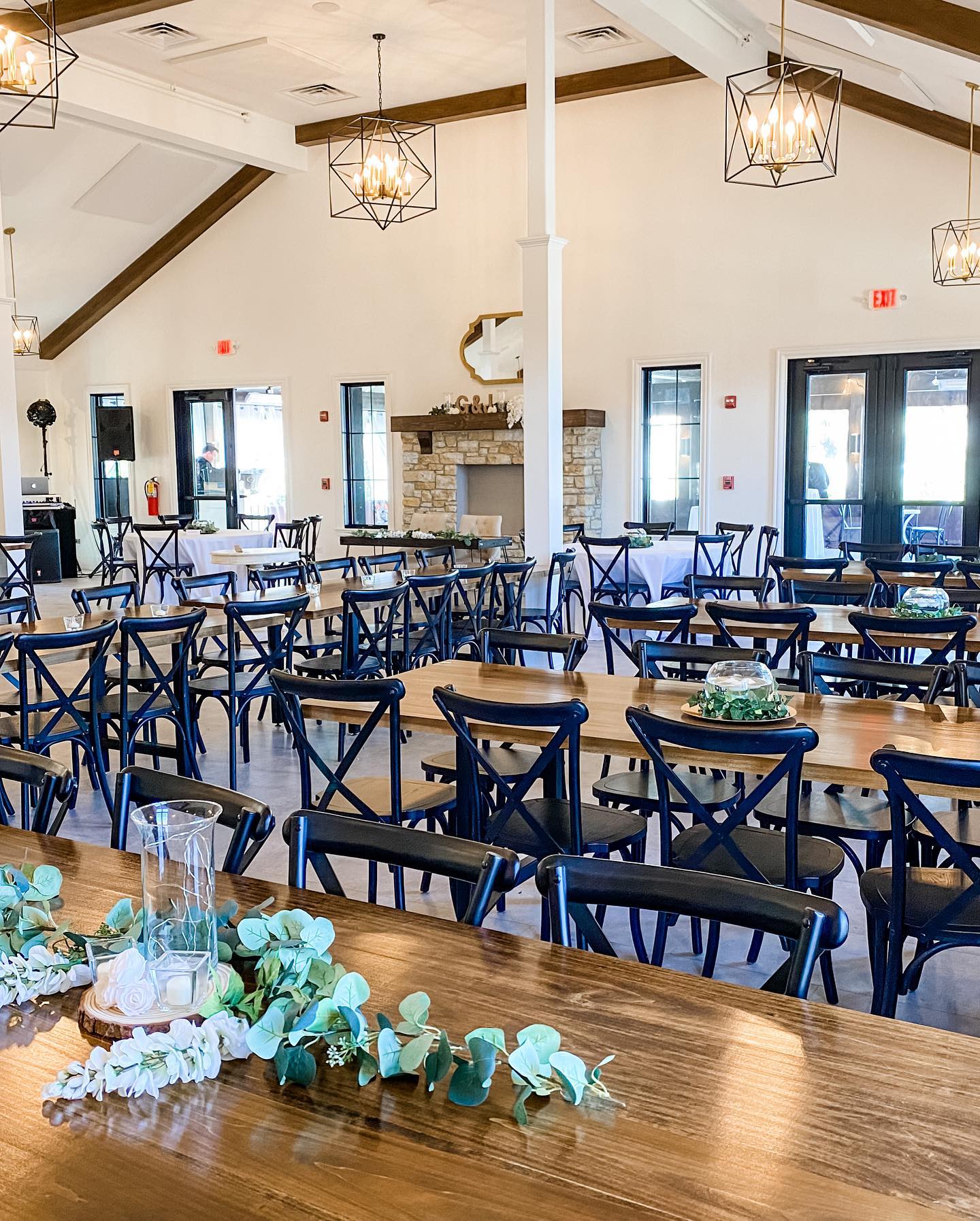 A large room with tables and chairs set up for a wedding reception.