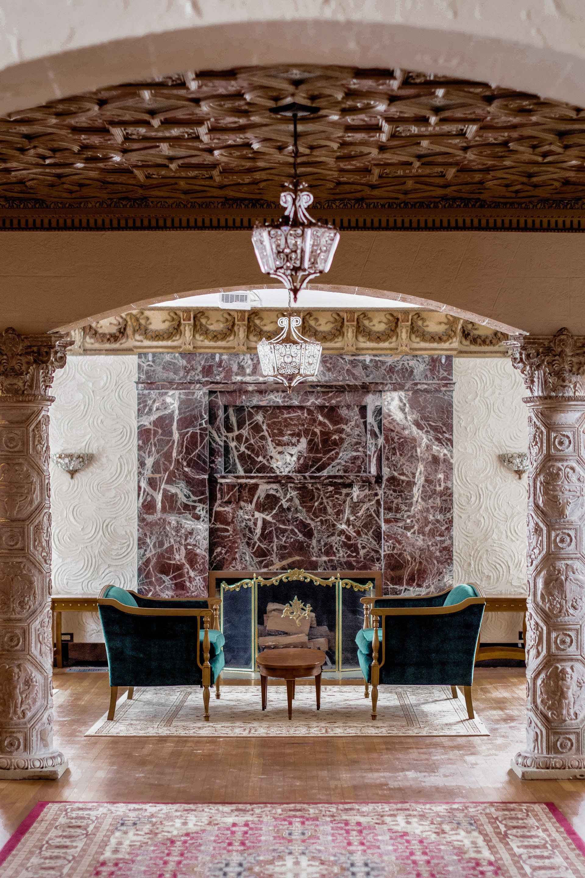A living room with a fireplace , chairs and a rug.