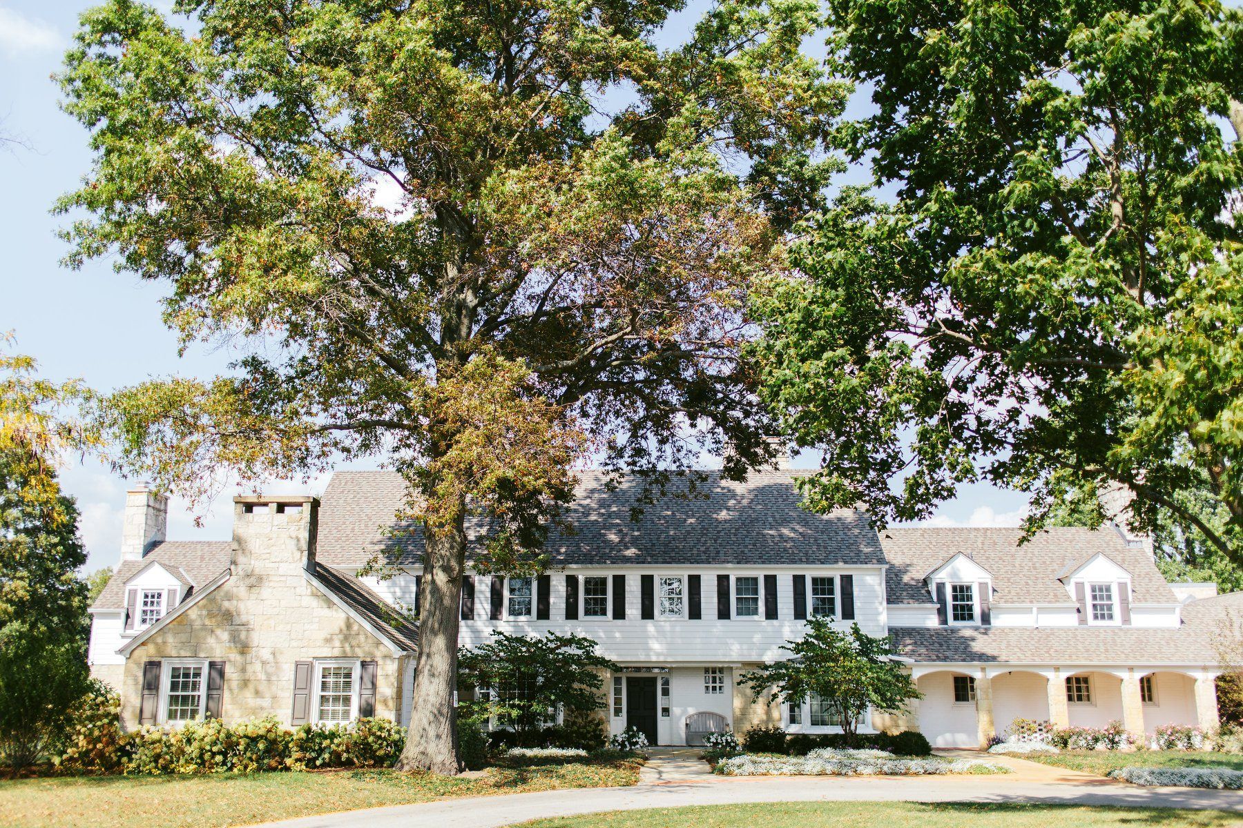 A large white house with a large tree in front of it.