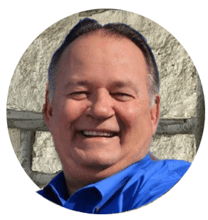 A man in a blue shirt is smiling in a circle.