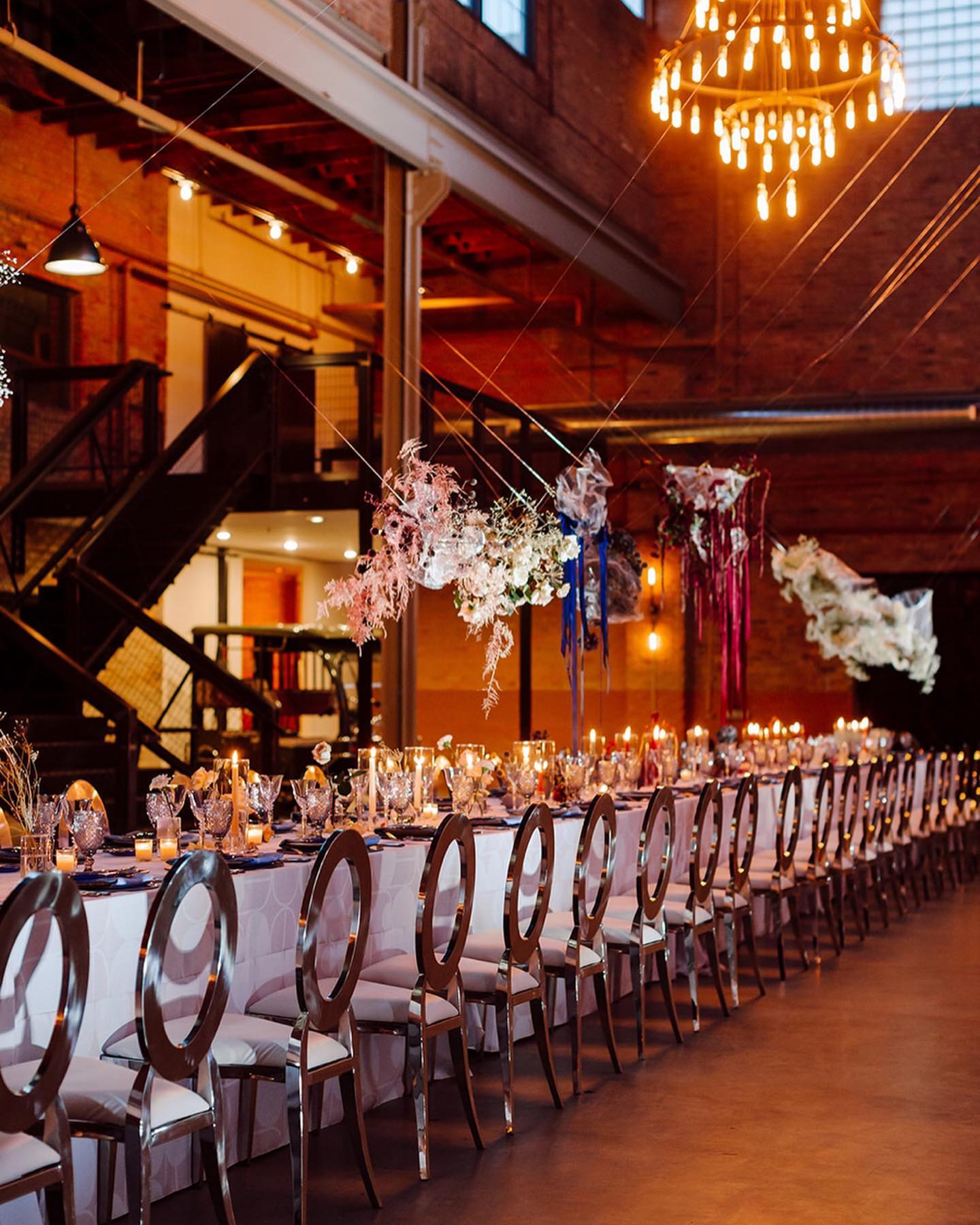 A large room with tables and chairs set up for a wedding reception