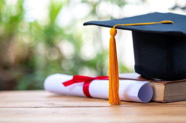 graduation cap and diploma on a wood table
