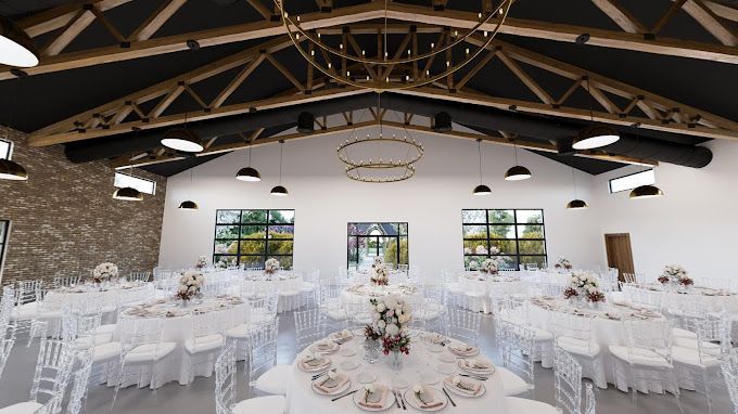 A white room with a vaulted wood ceiling in set with tables and chairs for a party.