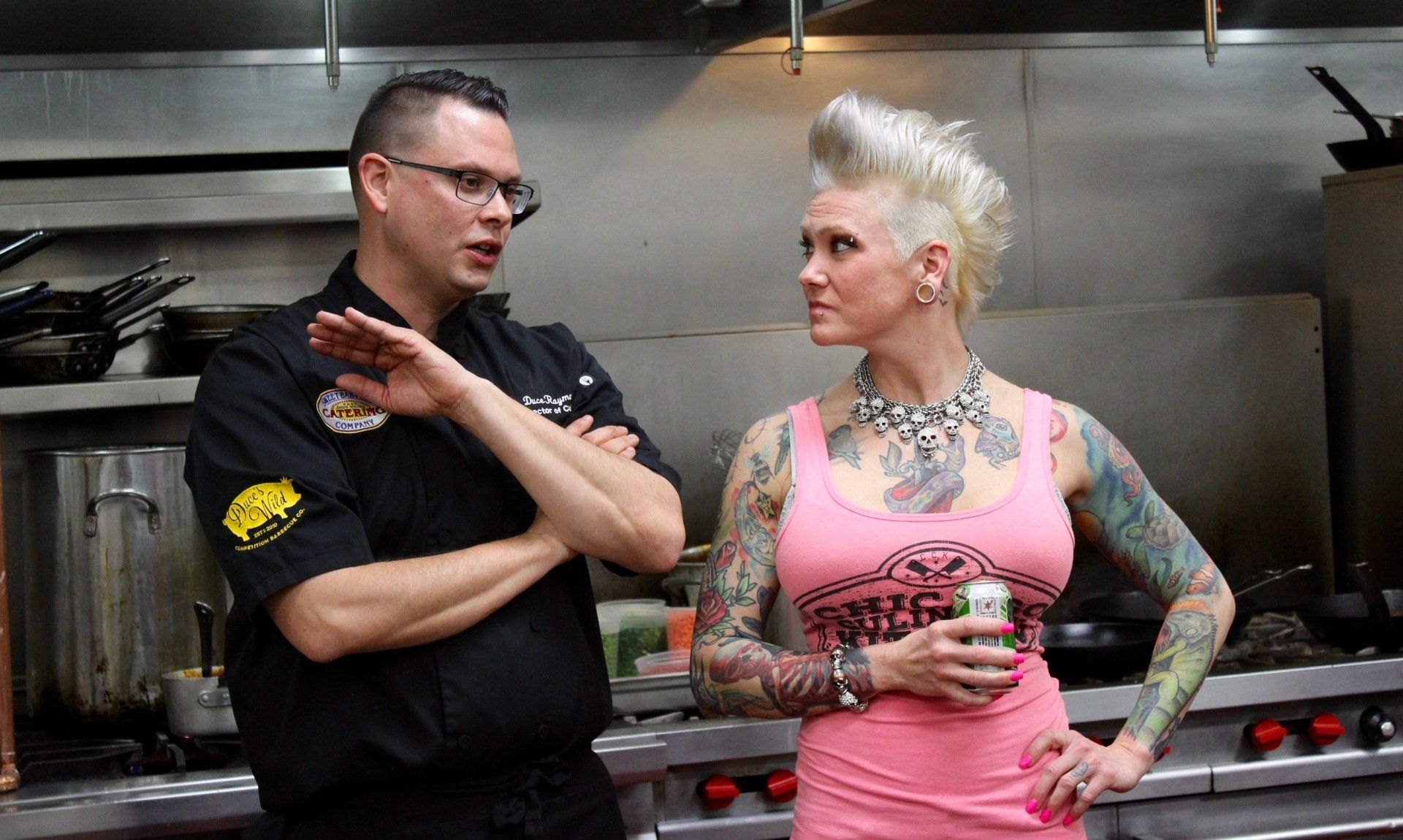 A man and a woman are standing next to each other in a kitchen.