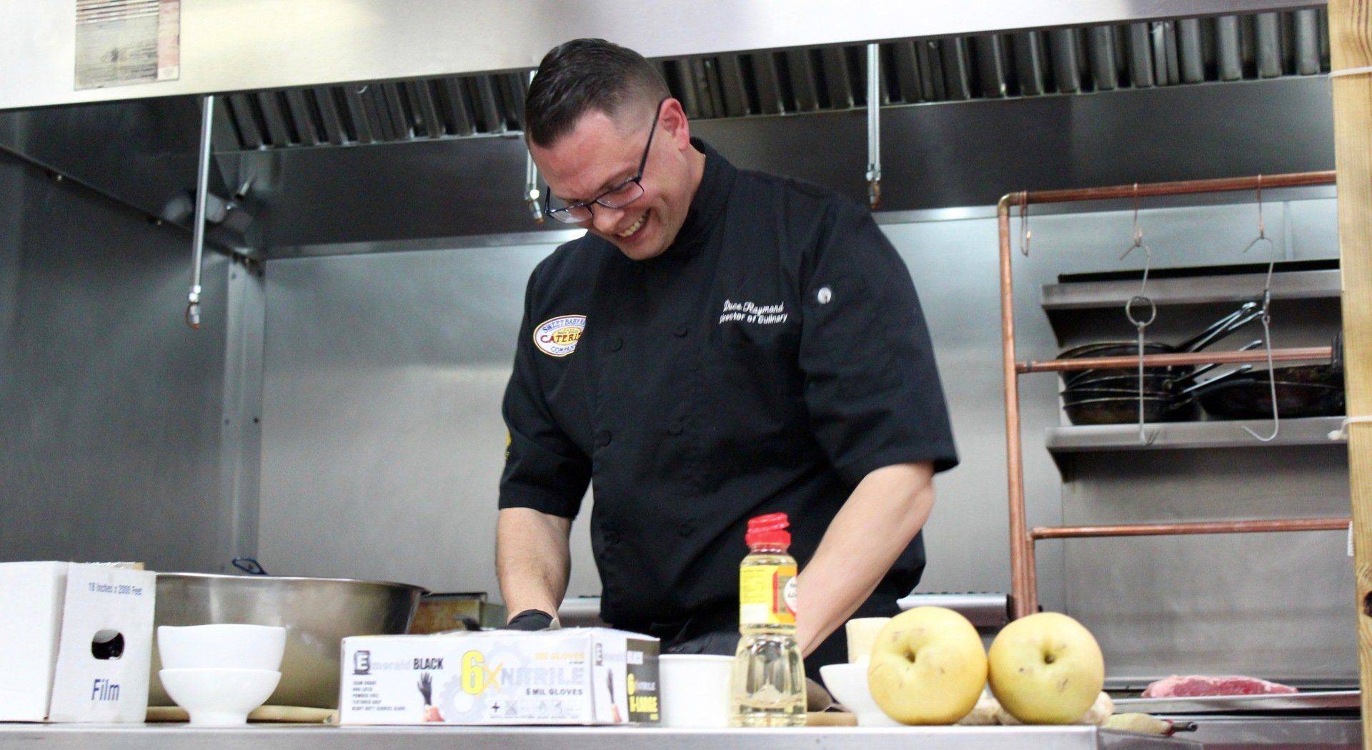 A man in a chef 's uniform is preparing food in a kitchen