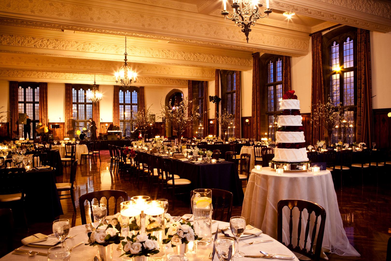 A large room with tables and chairs and a cake on the table