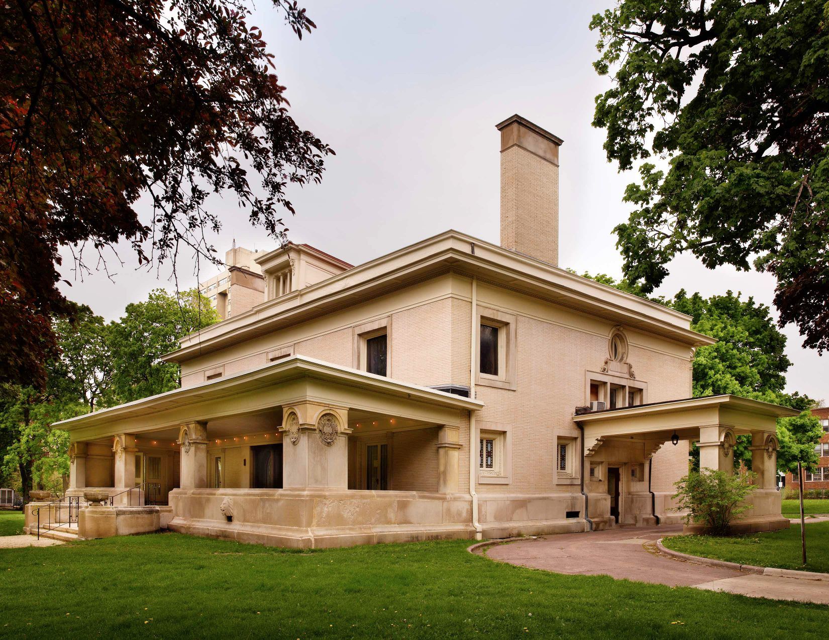 A large white house with a porch and a chimney