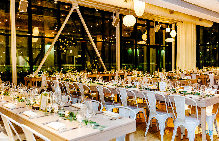 A large room with tables and chairs set up for a wedding reception.
