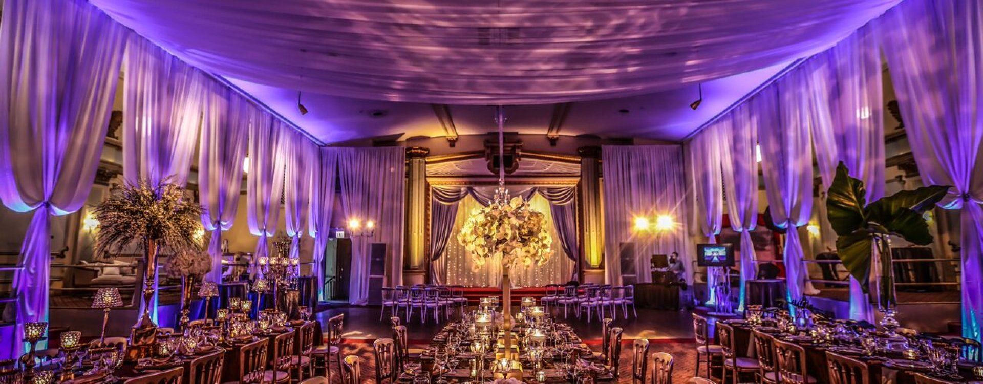 A large room filled with tables and chairs and purple lights.
