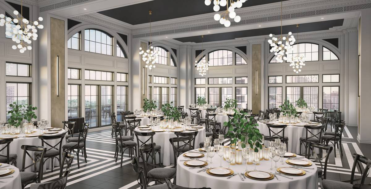 A large room with tables and chairs set up for a wedding reception.