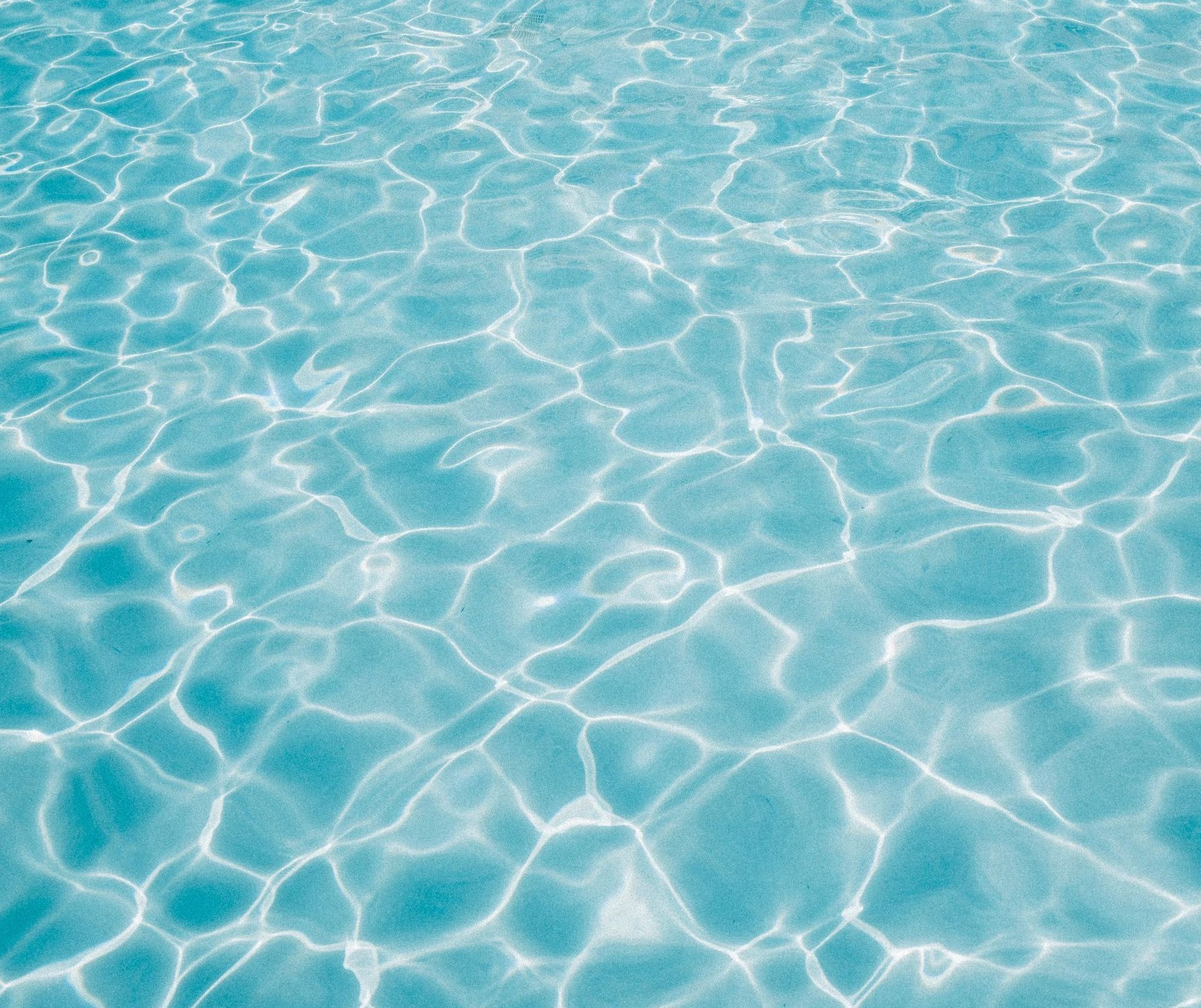 A stunningly kept swimming pool, overlooking a magnificent house.