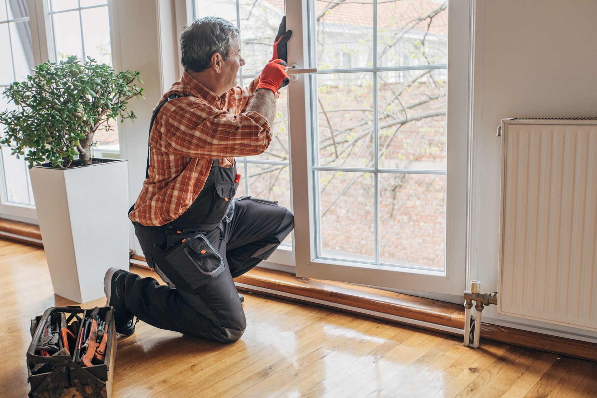 A technician adjusting a window as part of an interior remodeling service in a modern living room.