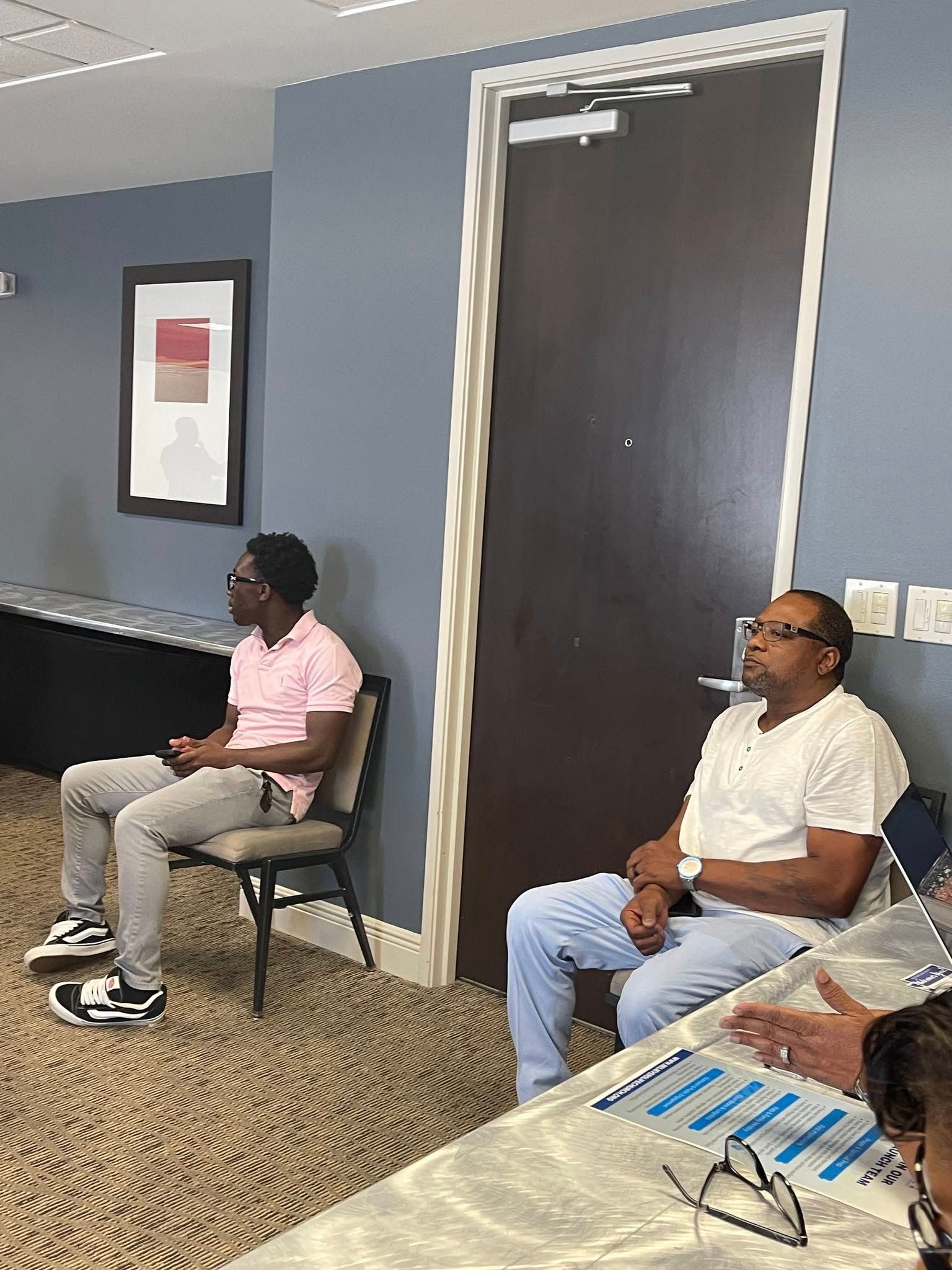 A group of men are sitting in chairs in a room.