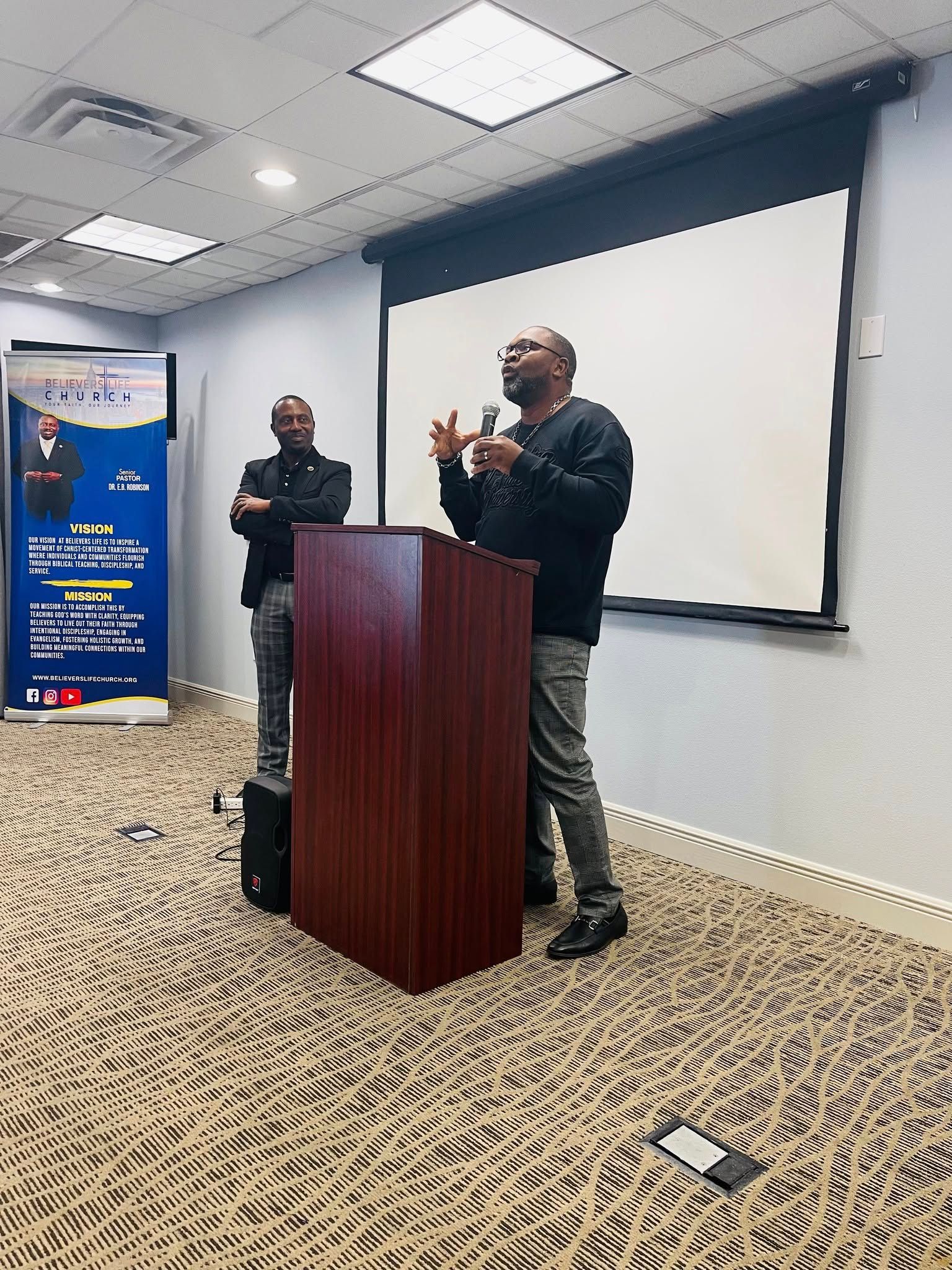 A man is standing at a podium giving a presentation
