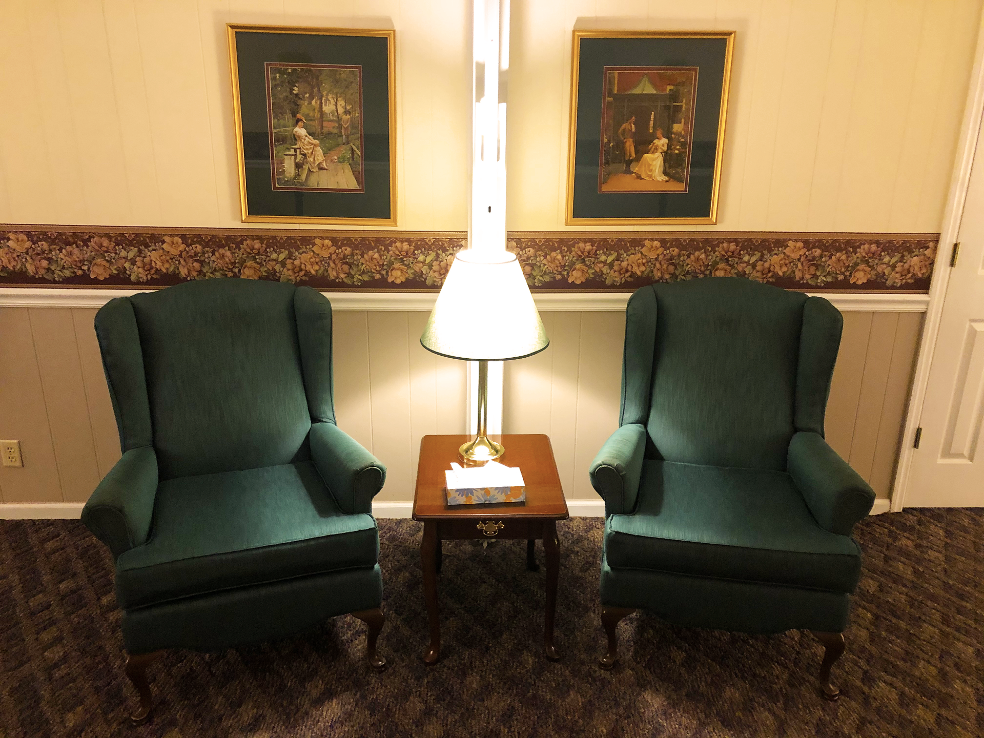 Two green chairs are sitting next to each other in a room