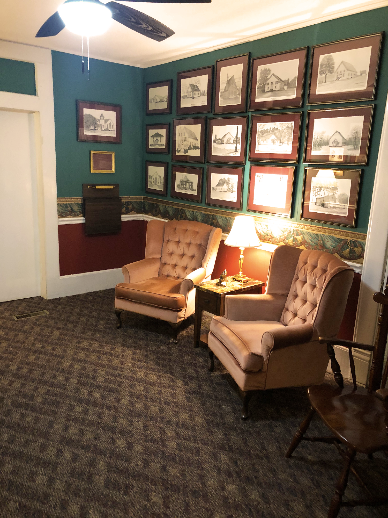 A living room with two chairs and a ceiling fan