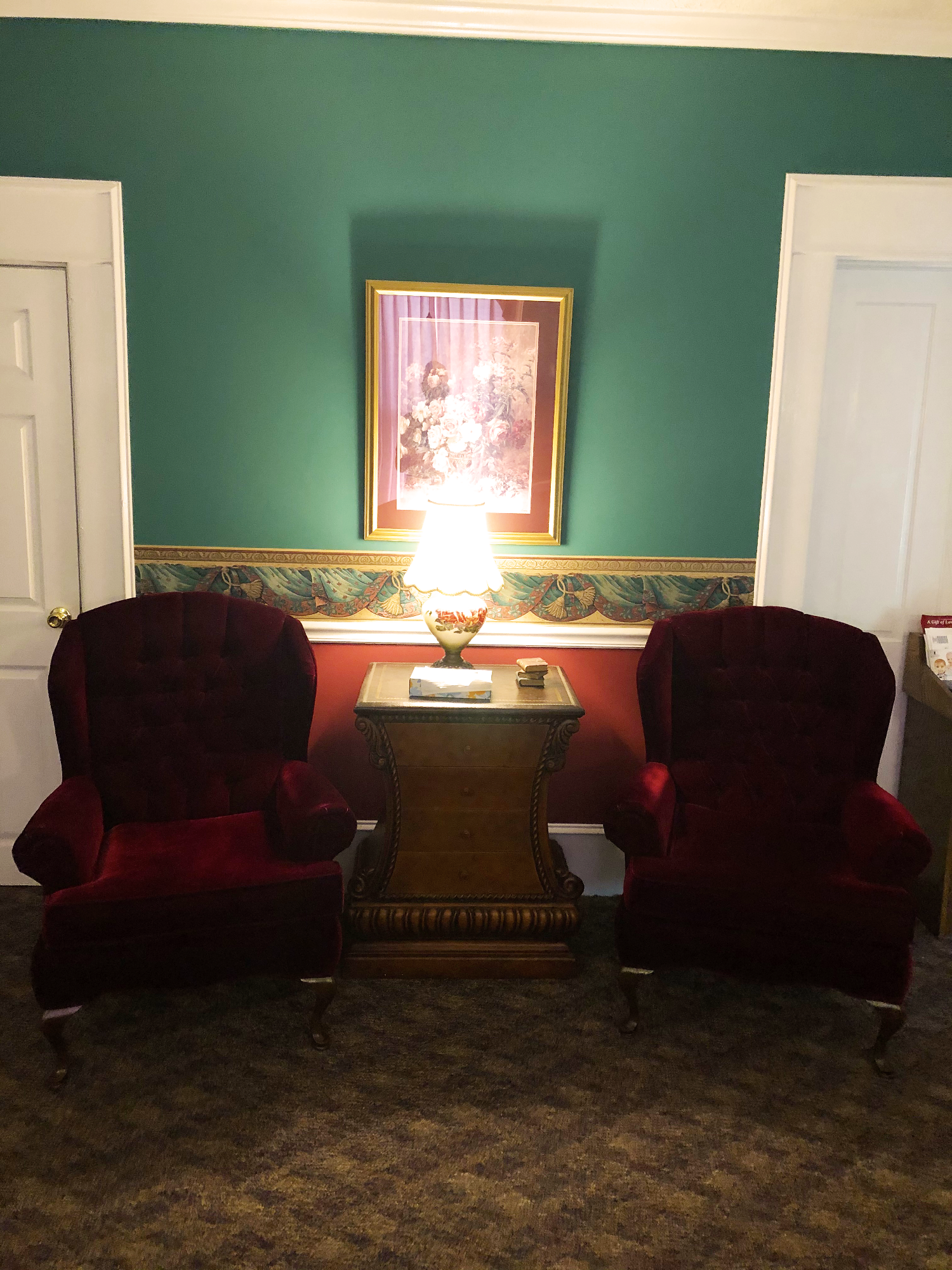 Two red chairs are in a room with green walls