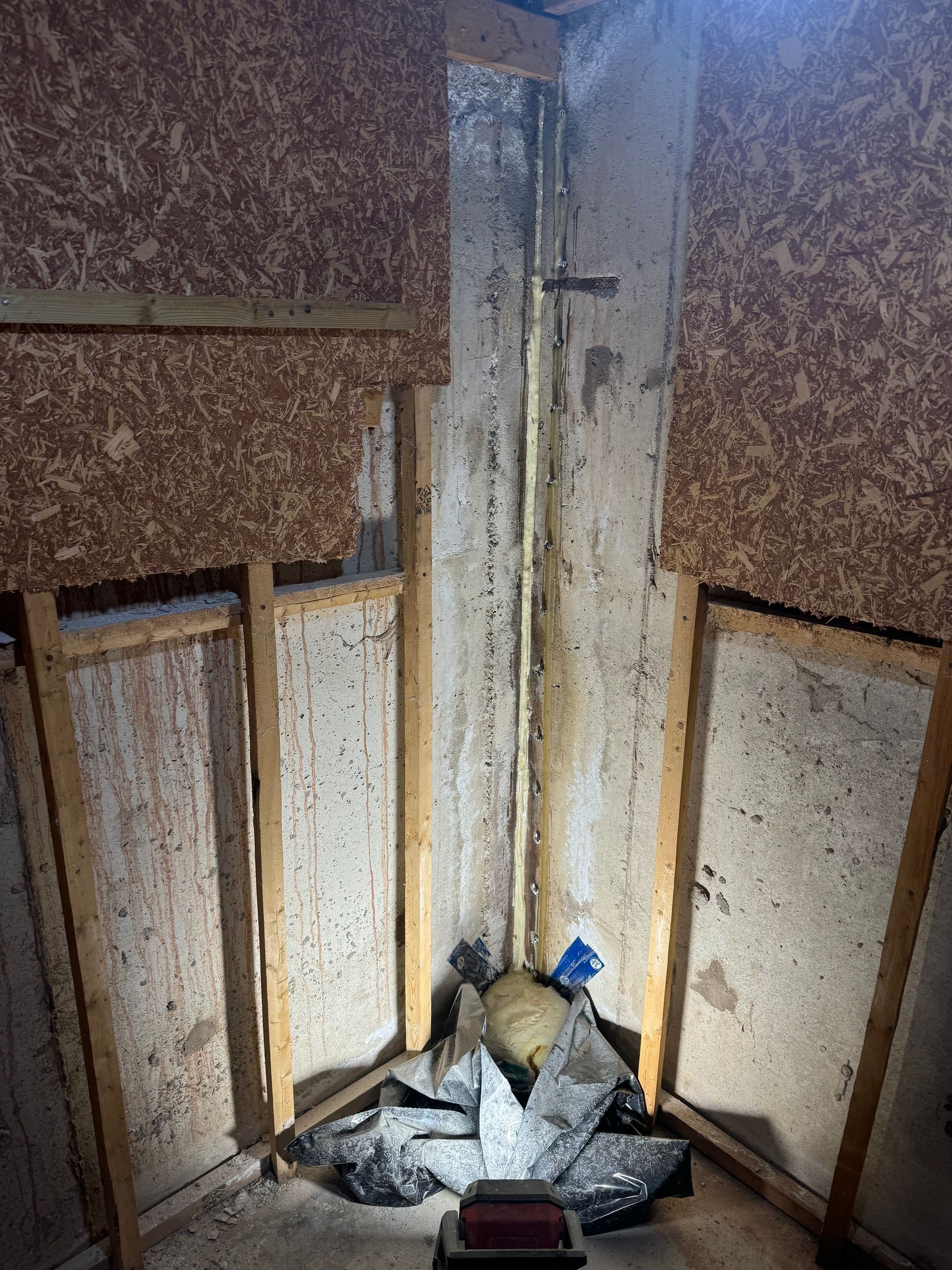 Cracked white stucco wall, vertical dark fissure.