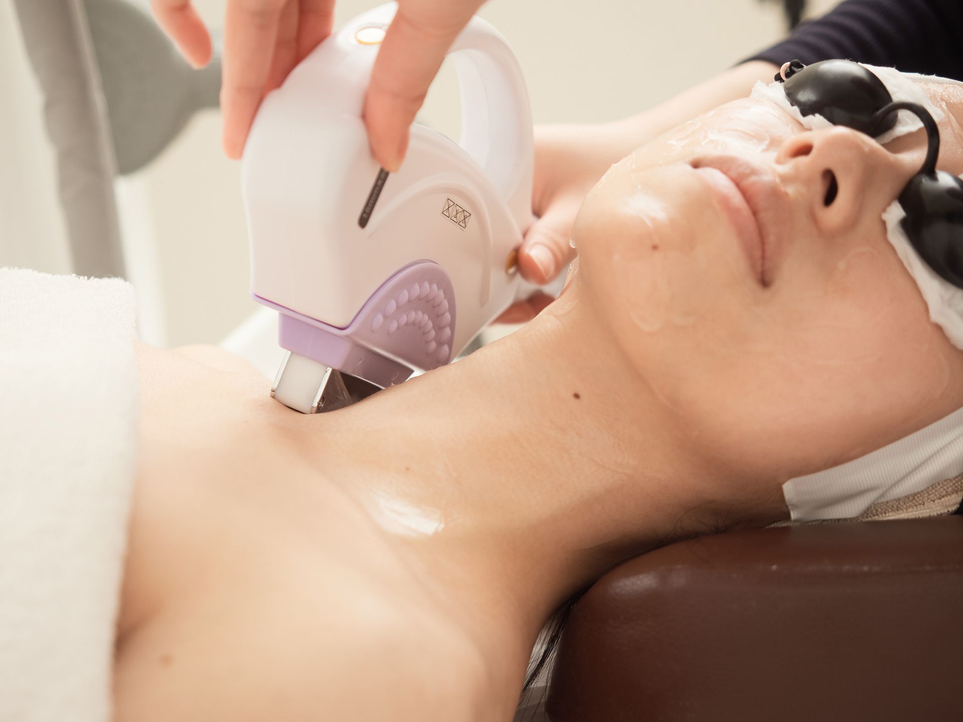 A woman is getting a laser treatment on her neck