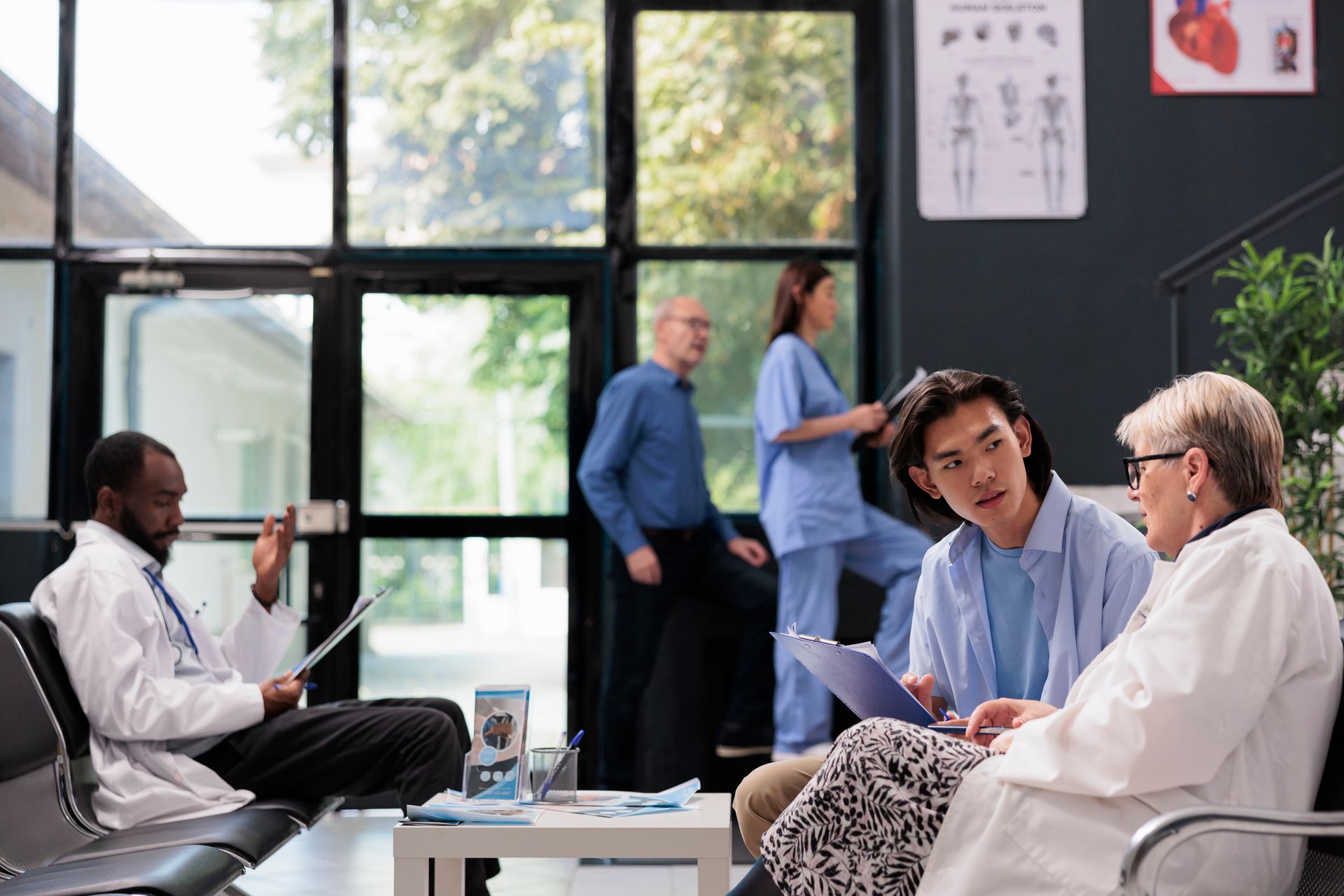A group of doctors and nurses are talking to a patient in a hospital waiting room.